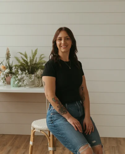Jess, the baker behind Just Sweets by Jess, sitting in her studio