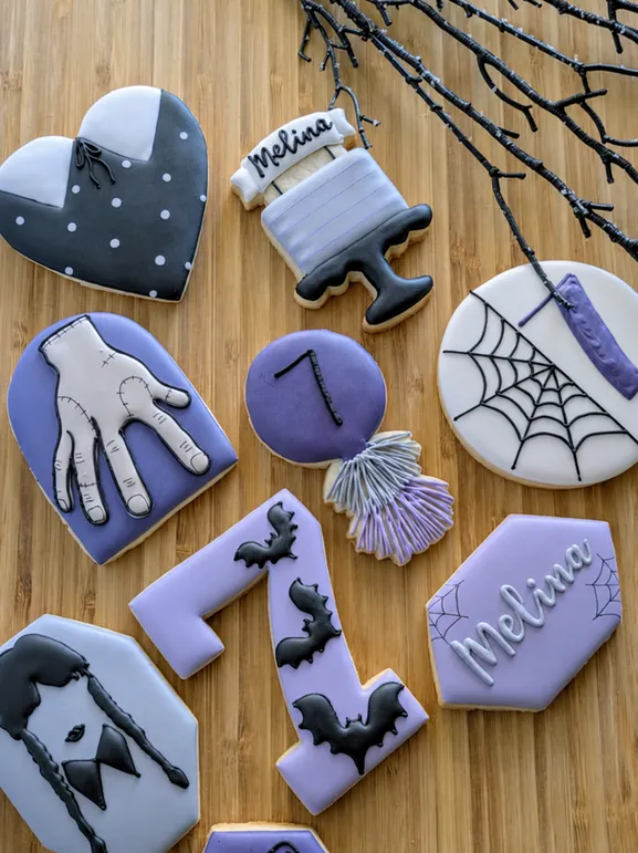 Halloween birthday cookies with Wednesday-inspired hands, spiderwebs and bats